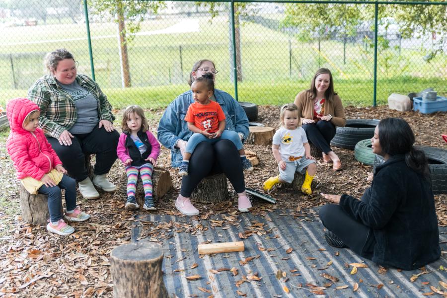 Children sitting and listening to their teacher